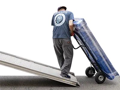 Commercial moving crew transporting large items with equipment
